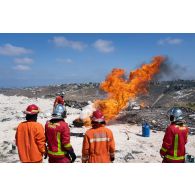 Un sapeur-pompier de la brigade de sapeurs-pompiers de Paris (BSPP) démontre l'extinction d'un incendie devant des pompiers malaisiens à Marakah, au Sud-Liban.