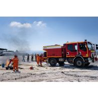 Un sapeur-pompier de la brigade de sapeurs-pompiers de Paris (BSPP) démontre l'extinction d'un incendie devant des pompiers malaisiens à Marakah, au Sud-Liban.