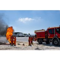 Un sapeur-pompier de la brigade de sapeurs-pompiers de Paris (BSPP) démontre l'extinction d'un incendie devant des pompiers malaisiens à Marakah, au Sud-Liban.