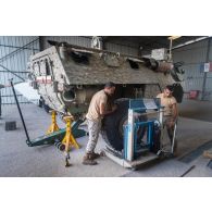 Des mécaniciens libanais interviennent sur la roue d'un véhicule de l'avant blindé (VAB) à l'atelier mécanique de Deir Kifa, au Sud-Liban.