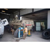 Des mécaniciens libanais interviennent sur la roue d'un véhicule de l'avant blindé (VAB) à l'atelier mécanique de Deir Kifa, au Sud-Liban.