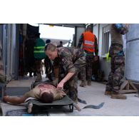 Une auxiliaire sanitaire prend en charge un blessé évacué par brancard pour un exercice à Deir Kiffa, au Sud-Liban.