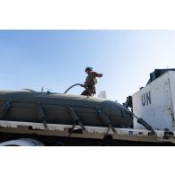 Un soldat installe une manche de raccordement sur un bac souple pour le ravitaillement en eau du camp de Nabatieh, au Sud-Liban.