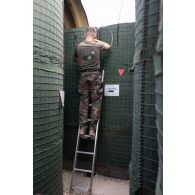 Unu technicien installe du câblage à l'abri d'un shelter lors d'une alerte à Deir Kifa, au Sud-Liban.