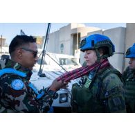 Un casque bleu népalais offre un khata tibétain à son homologue finlandais en remerciement de sa participation au déblaiement des ruines de la ville de Meiss El Jabal, au Sud-Liban.