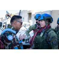 Un casque bleu népalais offre un khata tibétain à son homologue finlandais en remerciement de sa participation au déblaiement des ruines de la ville de Meiss El Jabal, au Sud-Liban.