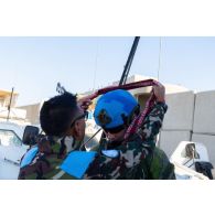 Un casque bleu népalais offre un khata tibétain à son homologue finlandais en remerciement de sa participation au déblaiement des ruines de Mess El Jabal, au Sud-Liban.