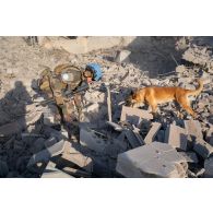Un démineur du groupement de plongeurs-démineurs de la Méditerranée (GPD-Med) aidé d'un chien inspecte les ruines de la ville de Meiss El Jabal, au Sud-Liban.