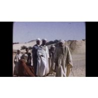 Fonds cinématographique de Pierre Marrel. Film « Sahara. El Oued. Le Souf (conférence aux habitants). El Hadjira - Ouargla - Sauterelles - Colbert ... Méchoui de juin 1958 (Lt Morat) ».