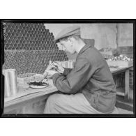 St Ouen. Usine Ruggieri. Confection des cartouches éclairantes pour fusils. Mise en place de l'allumeur. [légende d'origine]