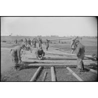 Des pionniers allemands dirigent des travaux de consolidation d'une route affaiblie par l'hiver.