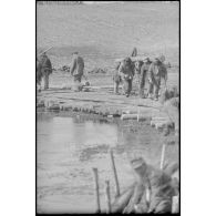 Des pionniers allemands dirigent des travaux de consolidation d'une route affaiblie par l'hiver.