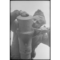 Au sein du Schwere Panzer Abteilung 519, un manque d'équipage d'un Nashorn effectue la maintenance du canon de 8,8 cm.