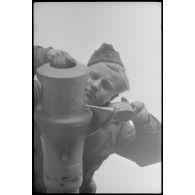 Au sein du Schwere Panzer Abteilung 519, un manque d'équipage d'un Nashorn effectue la maintenance du canon de 8,8 cm.