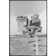 Des fantassins et des artilleurs du 519e bataillon lourd de chasseurs de chars (Schwere Panzerjäger Abteilung 519) observent le champ de bataille sur le toit d'une isba.