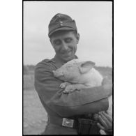 Portrait d'un soldat portant dans ses bras un porcelet.