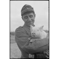 Portrait d'un soldat portant dans ses bras un porcelet.