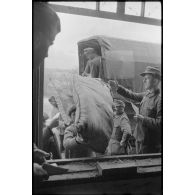 Déchargement de camions par des soldats allemands et des civils requis.