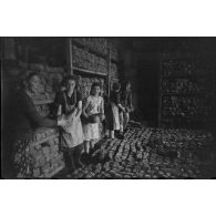 Des femmes et un soldat allemand assemblent des montagnes de pain.