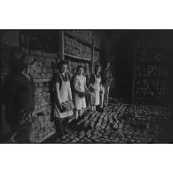 Des femmes et un soldat allemand assemblent des montagnes de pain.