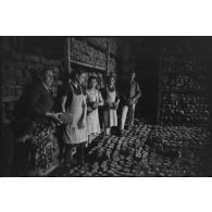 Des femmes et un soldat allemand assemblent des montagnes de pain.