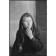 Portrait d'une jeune femme répondant à des questions, il pourrait s'agir d'un interrogatoire.