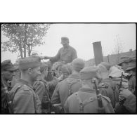 Des fantassins rassemblés devant une cuisine de campagne.