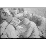 Des ouvriers prisonniers examinent un exemplaire du magazine Signal.