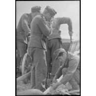 Des fantassins allemandes réparent une charrette qui transportera leurs effets personnels.