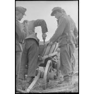 Des fantassins allemandes réparent une charrette qui transportera leurs effets personnels.