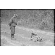Un pionnier retire une mine sous les yeux d'un sous-officier.
