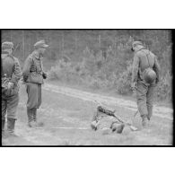 Un pionnier retire une mine sous les yeux d'un sous-officier.