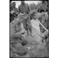 Des pionniers du Génie allemand fixent une mèche à de l'explosif.