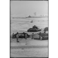 Un équipage d'un canon d'assaut examine deux carcasses de chars soviétiques T-34.