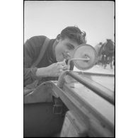 Un fantassins se rase en s'aidant d'un rétro-viseur d'un véhicule amphibie Schwimmwagen.