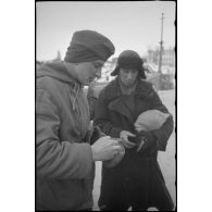 Un soldat effectue un contrôle des papiers d'identité de deux passantes.