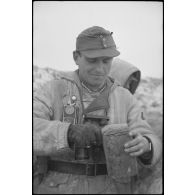 Un lieutenant (Leutnant) d'une unité de Panzergrenadier coupe une tranche de pain noir.