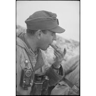 Un lieutenant (Leutnant) d'une unité de Panzergrenadier coupe une tranche de pain noir.