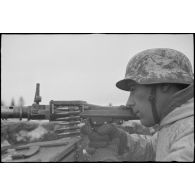 Tireur et pourvoyeur derrière une mitrailleuse MG-34 en pleine action.