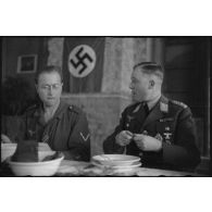 Le général (Generalleutnant) Robert Pistorius partage un repas avec des hommes 4e division d'infanterie de l'armée de l'air allemande après avoir prononcé un discours.