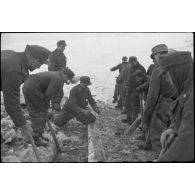 Pris dans la glace, les rondins qui consolidaient la route sont détruits à l'aide d'explosifs.