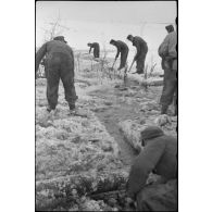 Pris dans la glace, les rondins qui consolidaient la route sont détruits à l'aide d'explosifs.