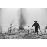 Pris dans la glace, les rondins qui consolidaient la route sont détruits à l'aide d'explosifs.