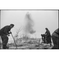 Pris dans la glace, les rondins qui consolidaient la route sont détruits à l'aide d'explosifs.