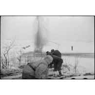 Pris dans la glace, les rondins qui consolidaient la route sont détruits à l'aide d'explosifs.