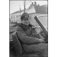 Le général (Generalleutnant) Rolf Wuthmann monte à bord d'une décapotable et quitte le quartier général où s'est déroulée une réunion.