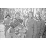 Un prisonnier soviétique, employé à la construction d'un pont, s'intéresse à l'appareil photographique Leica du reporter.