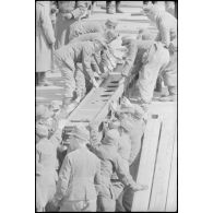 Déploiement de poutres métalliques du ponton (Brückegerät) pour faire descendre ou monter un véhicule.