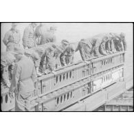 Déploiement de poutres métalliques du ponton (Brückegerät) pour faire descendre ou monter un véhicule.