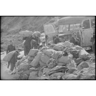 Aprés avoir été déchargés, des sacs postaux sont portés jusqu'à un bus qui assure le transport vers les destinataires.